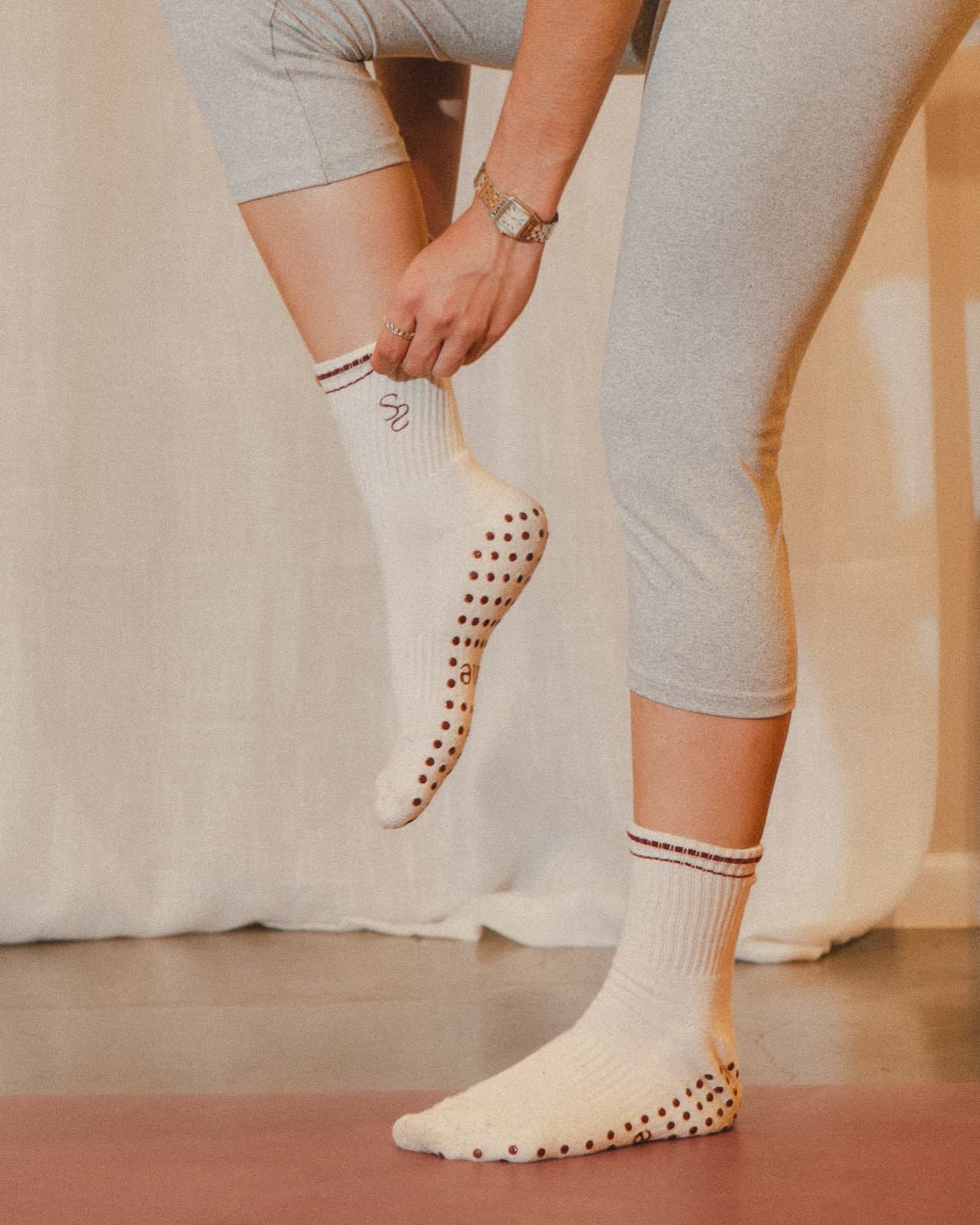 Grip socks with the Sane monogram, laced up before class